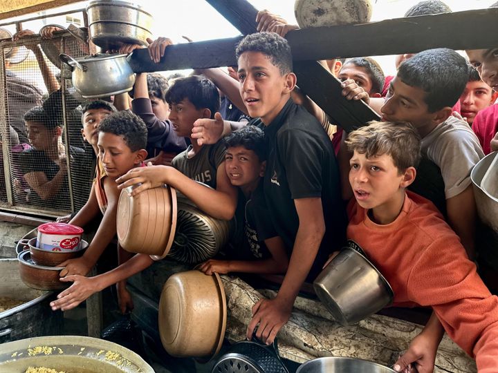 رفح، غزة - 03 مايو 2024: أطفال في مدينة رفح يصطفون للحصول على وعاء من الطعام لأسرهم من المنظمات الخيرية، في رفح، غزة في 03 مايو 2024. مع استمرار الهجمات الإسرائيلية على قطاع غزة بلا هوادة، فإن الحصار الكامل المفروض على قطاع غزة وقد تركت هذه الأراضي الفلسطينيين غير قادرين على الحصول على العديد من الاحتياجات الحيوية، بما في ذلك الإمدادات الغذائية الأساسية.  (تصوير دعاء الباز/ الأناضول عبر غيتي إيماجز)